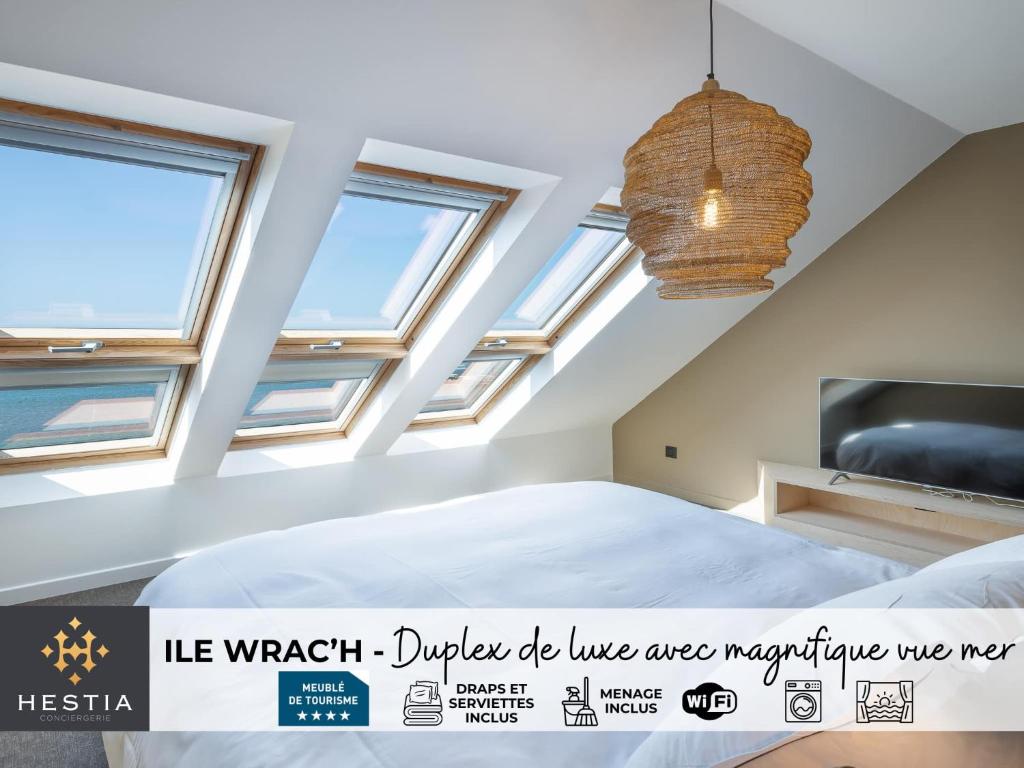 a bedroom with skylights and a bed and a tv at ILE WRACH - Duplex de luxe avec magnifique vue mer in Landéda