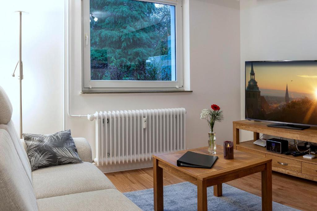a living room with a couch and a tv and a table at Ferienwohnung Kastanienblick in Uelzen