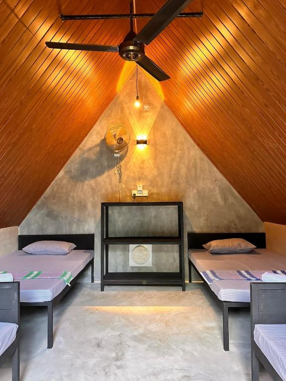 two beds in a room with a ceiling at Riverston Basecamp in Meda-Ela
