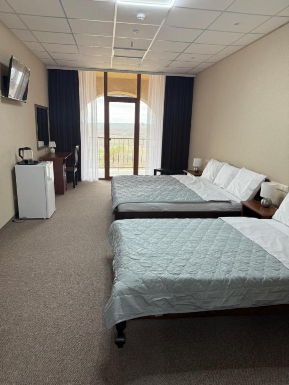 a hotel room with two beds and a desk at Cмак бажання in Sebino