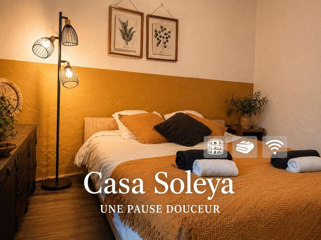 a bedroom with a bed with two pillows on it at Casa Soleya - Arènes de Nîmes - Au cœur de la cité Romaine in Nîmes