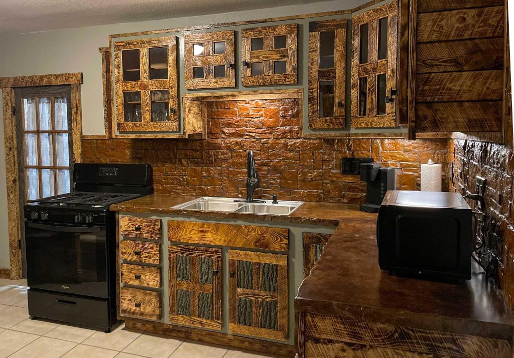 a kitchen with wooden cabinets and a sink and a stove at The Miner's Getaway in Lead SD in Lead