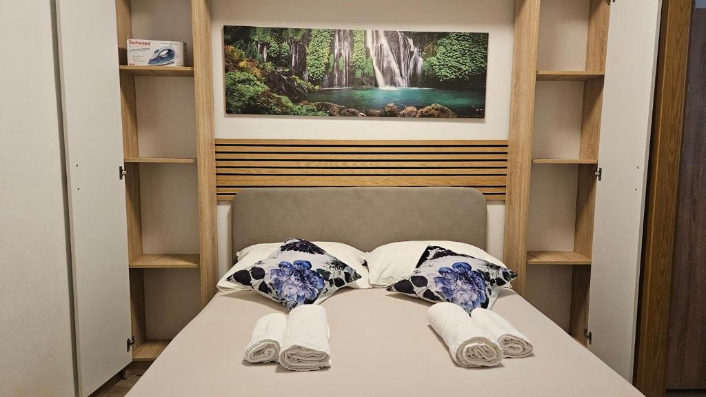 a room with a bed with two pillows and a painting at Apartment Sara in Koper