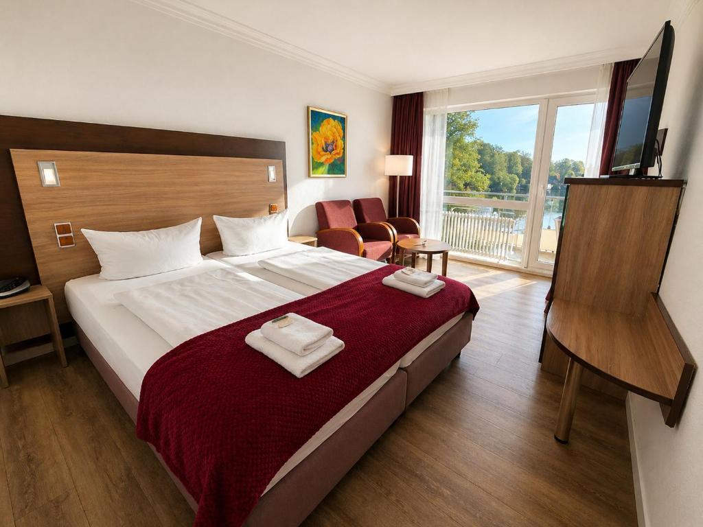 a hotel room with a large bed and a window at Seehotel Schwanenhof in Mölln