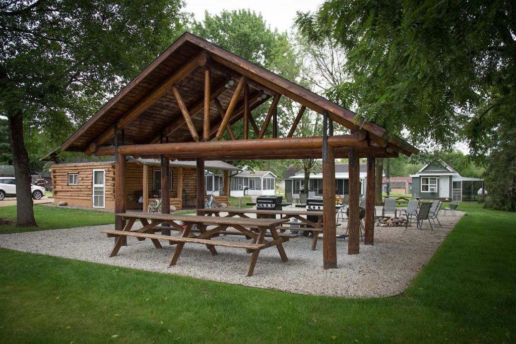 a pavilion with picnic tables and chairs in a park at Big River Escape Riverside Cabins in Buffalo City