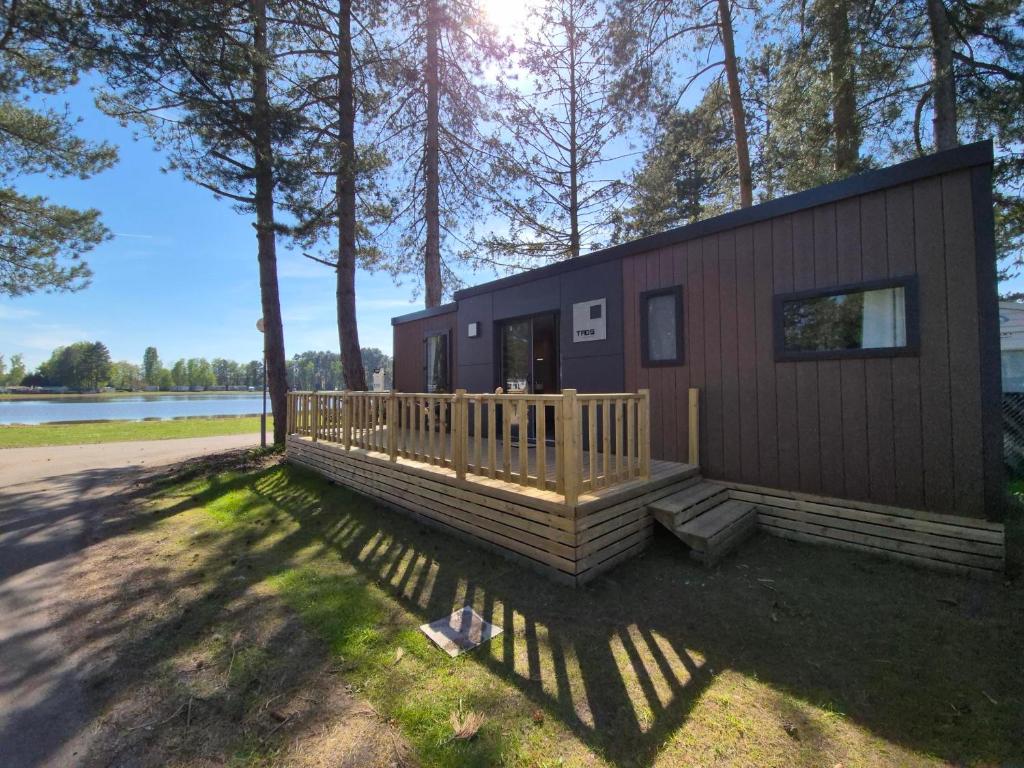 a tiny house with a porch and a deck at Stellira - Vakantieverblijf in Zonhoven