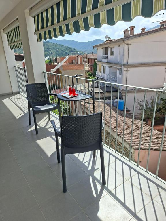 a patio with two chairs and a table on a balcony at il PORTICO in Tertenìa