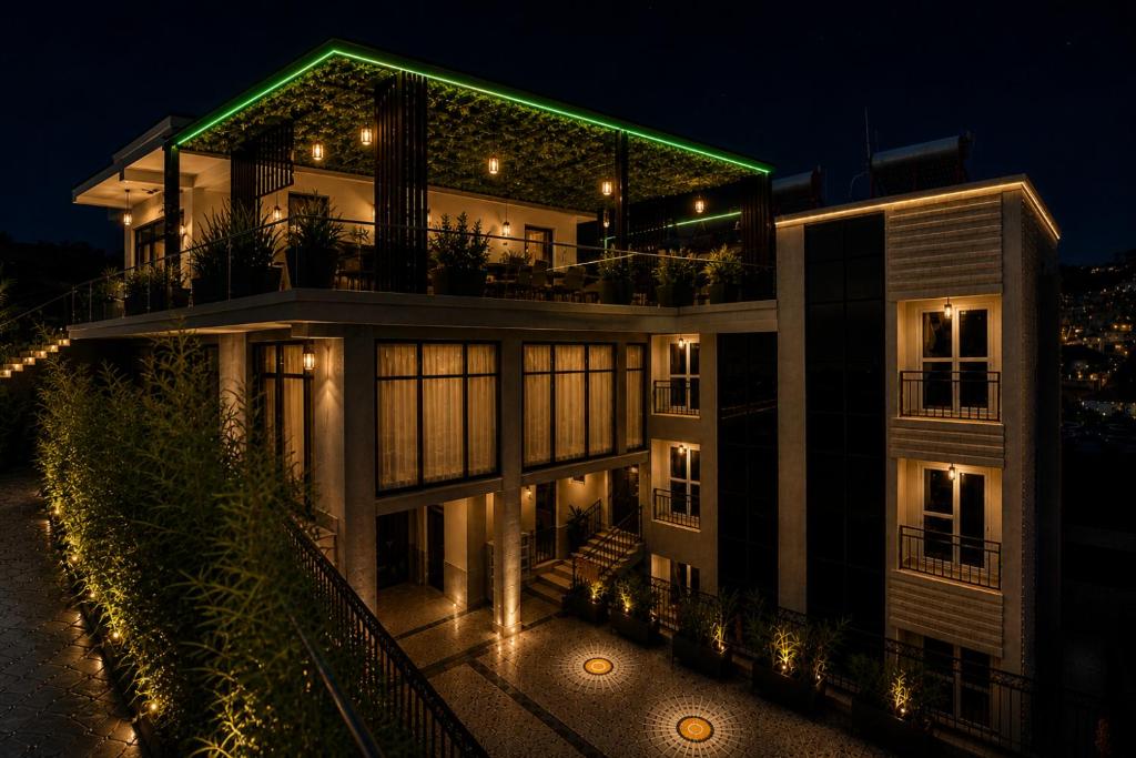 a large building with a green roof at night at Cape Town K Hotel in Kigali
