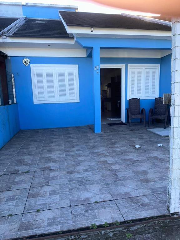 a house with a blue wall and a patio at Germinada in Imbé