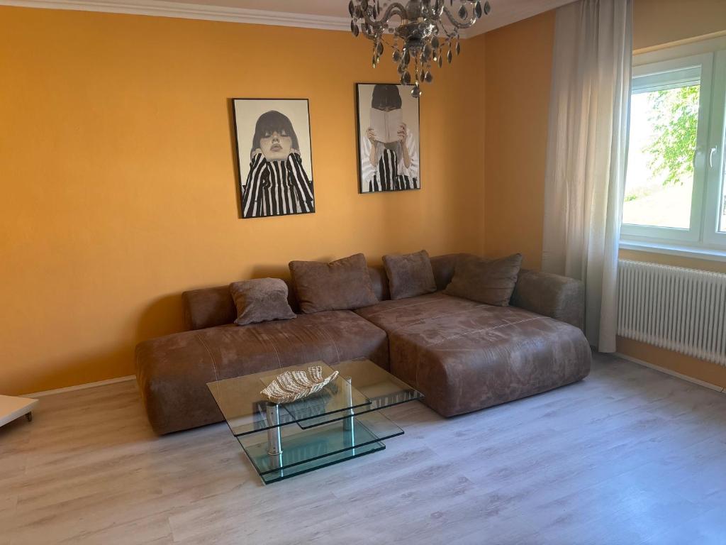 a living room with a brown couch and a glass table at Haus 4 you in Winden am See