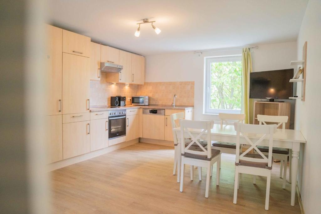 a kitchen with a table and chairs in a room at Ferienwohnung Kaufmann 3 in Rabenkirchen-Faulück