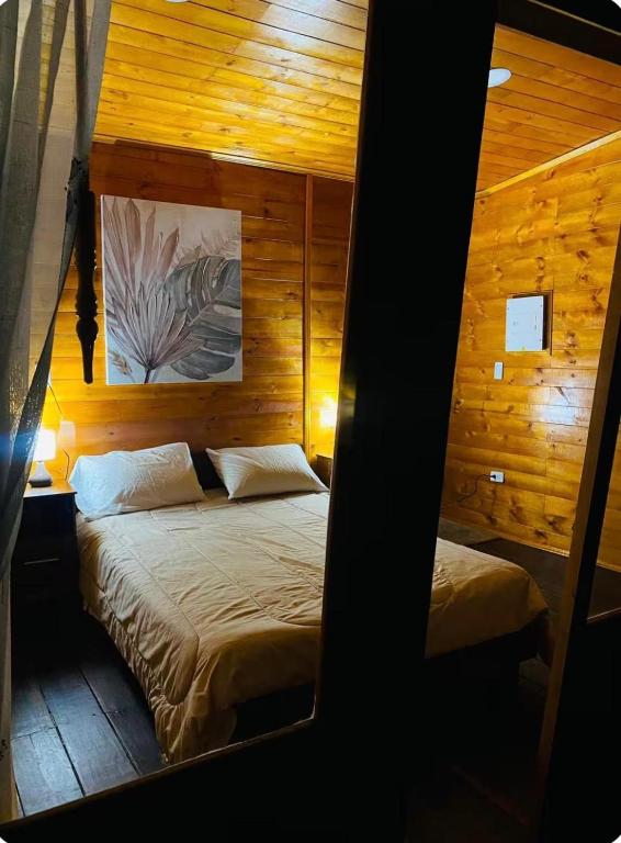 a bedroom with two beds in a wooden room at La Cima Bachué in Ubaque