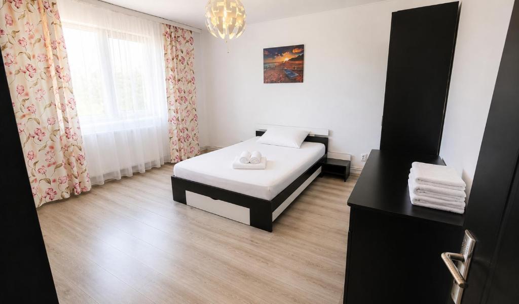 a small bedroom with a bed and a window at Apartament Vila Draghici Eforie Sud in Eforie Sud