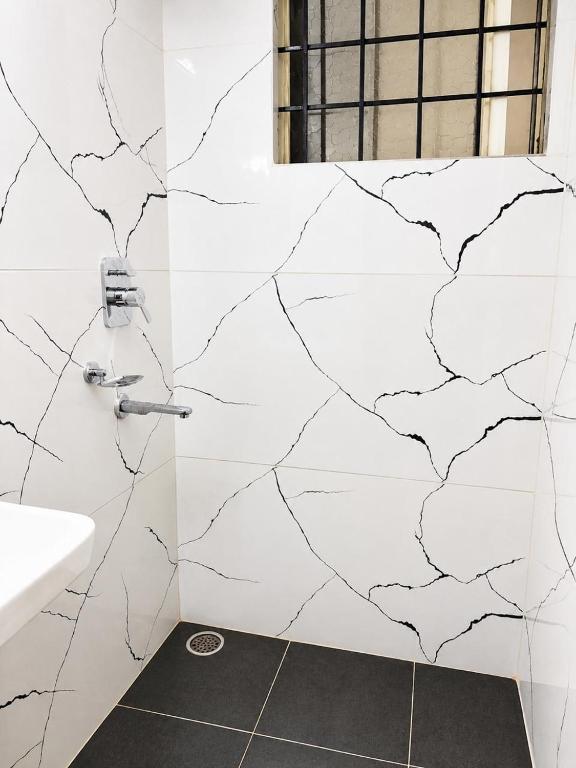 a bathroom with a sink and a white wall at Classic Comfort in Chikmagalūr