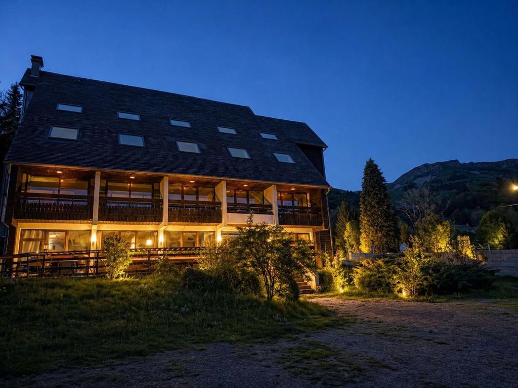 a large building with lights in front of it at night at Residence L'Horizon in Murat-le-Quaire