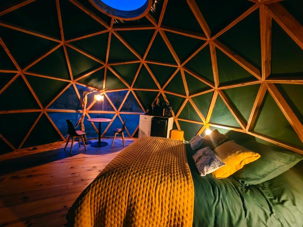 a room with a bed in a triangular shaped room at Le Havre de Chaux in La Bretenière