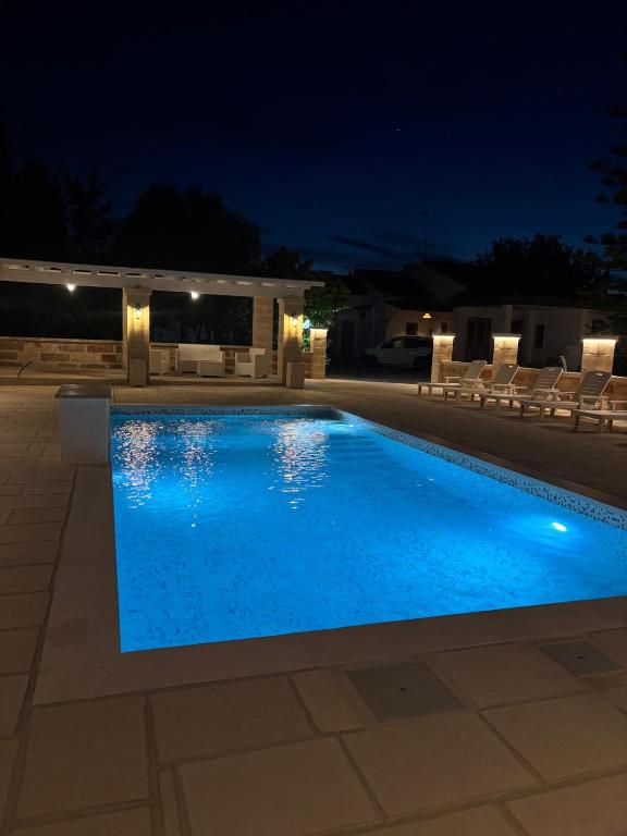 a swimming pool at night with chairs and lights at Villa Noesyr in Neviano