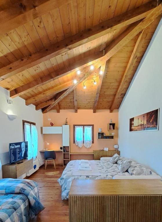 a bedroom with a large bed and wooden ceilings at open space apt - comodo a Venezia in Treviso