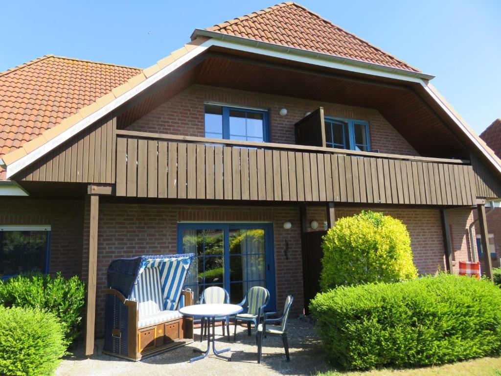 a house with chairs and a table in front of it at Ferienwohnung Bartels in Petersdorf mit Terrasse in Fehmarn