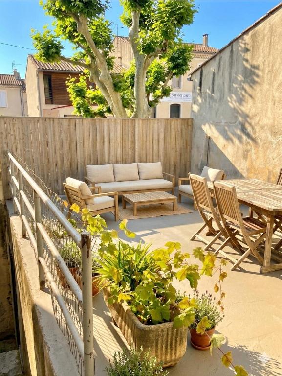a patio with chairs and a table and some plants at Another World Village house in Buis-les-Baronnies