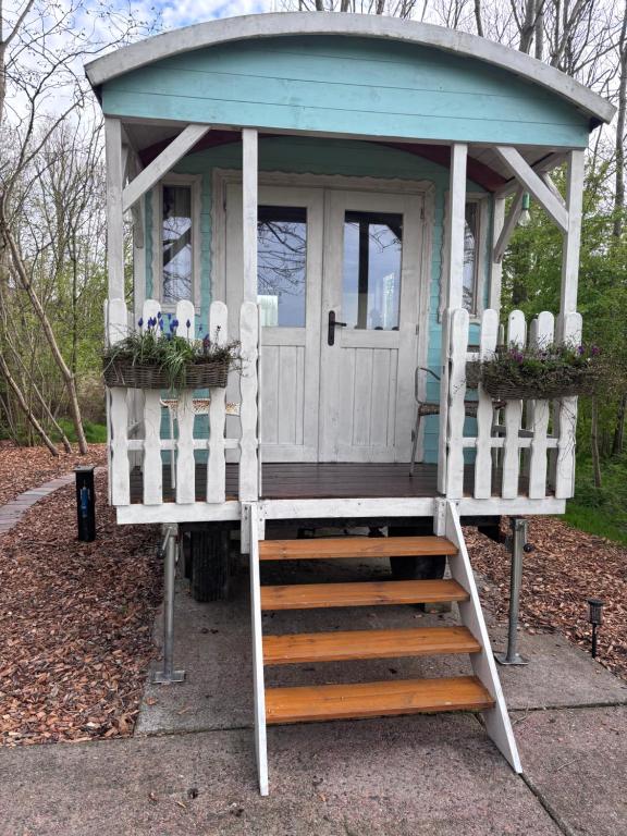 a small play house with stairs leading to it at Pipowagen Utewyn in Reitsum