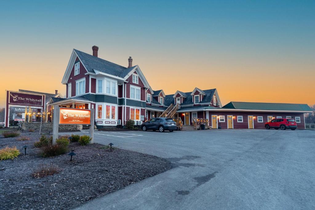 a large house with cars parked in a parking lot at The Whitetail Inn and Suites- Lincoln in Lincoln