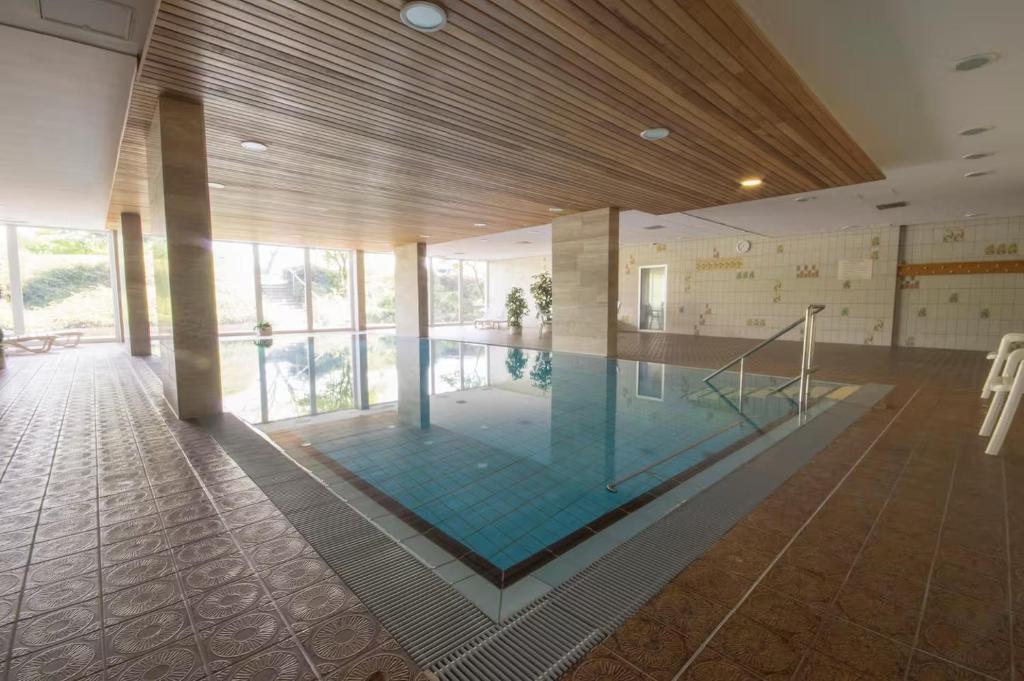 a large swimming pool in a building with a pool at Strandloft Cuxhaven im Haus Frauenpreiß Sahlenburg - strandnah - 2 Hunde willkommen -Schwimmbad - Sauna - direkt am Wald - Dachterrasse mit Blick nach Neuwerk in Cuxhaven