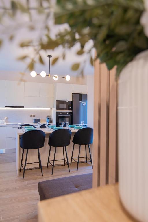 a kitchen with two chairs and a table with a counter at La Marine Apartments in Kalandra