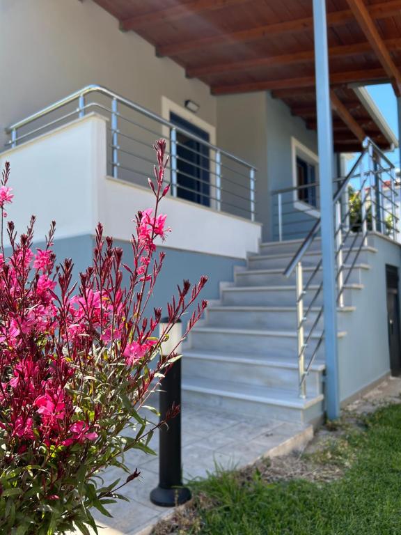a house with stairs and pink flowers in front of it at Ada's House 2 in Mytikas