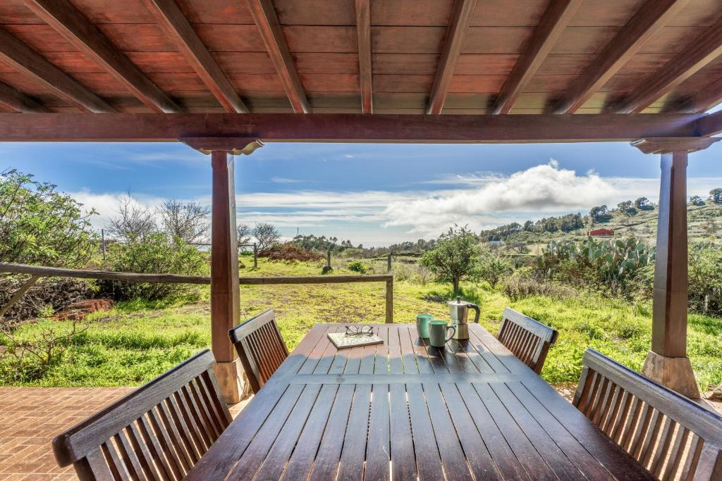 a wooden deck with a table and chairs on it at vv Casa Rural El Pajar in El Pinar del Hierro