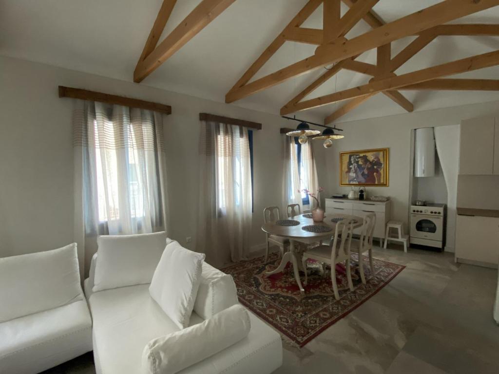 a living room with a white couch and a table at Hercules Historic Apartments in Chalkida