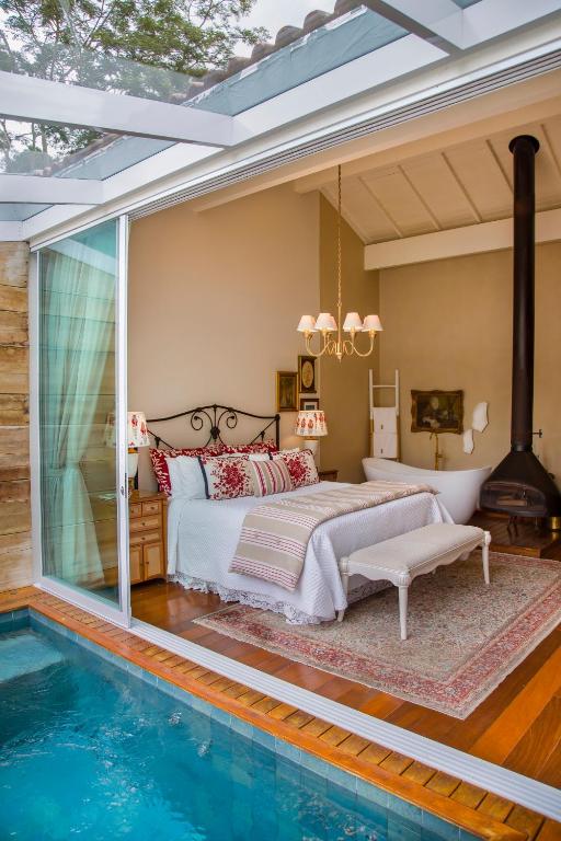 a bedroom with a bed next to a swimming pool at Pousada Rabo do Lagarto in Pedra Azul