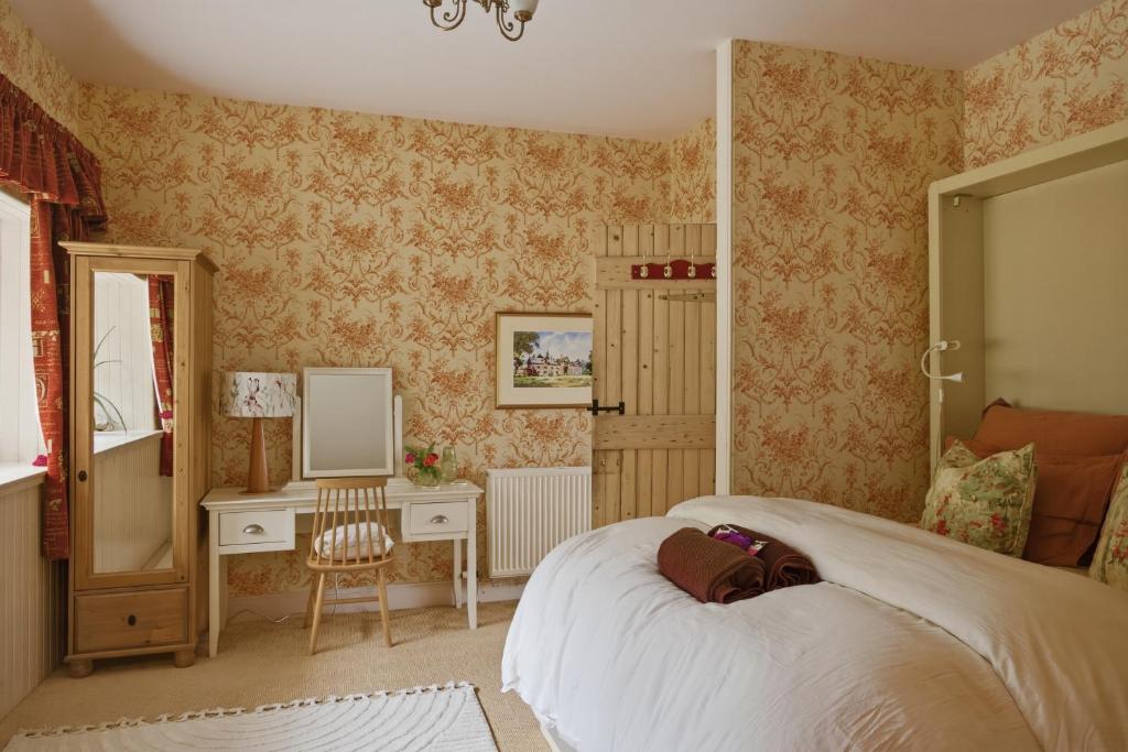 a bedroom with a bed and a desk and a mirror at The Archway Suite in Peebles