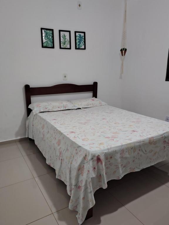 a bed in a white room with a bedspread on it at Recanto do Tião in Itapira