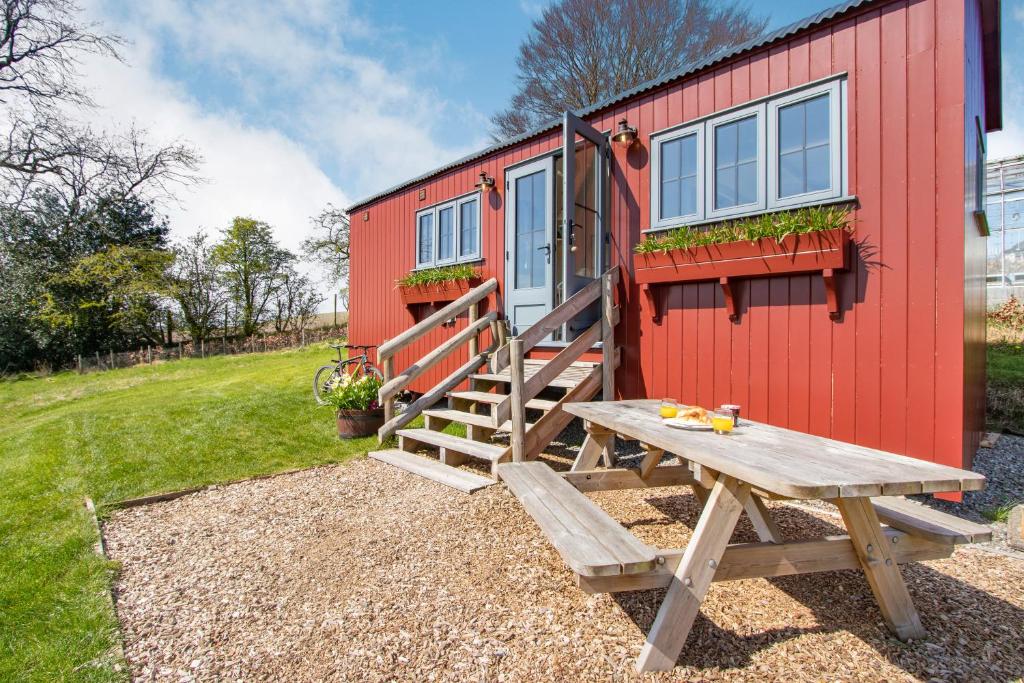 a picnic table in front of a tiny house at Bankhead Shepherds Hut in Stirling