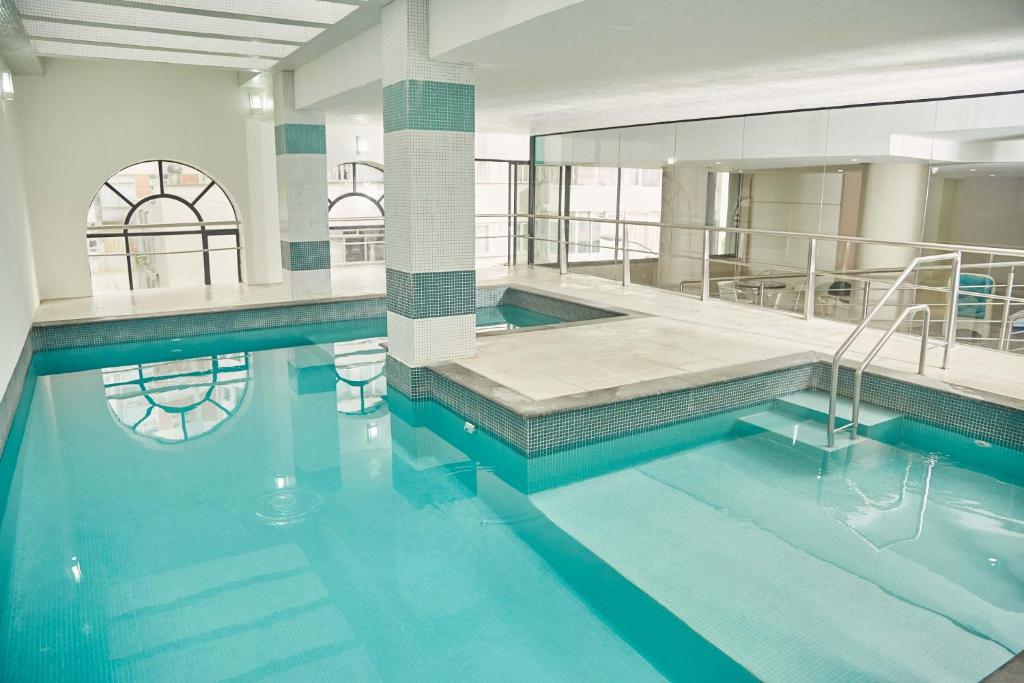 uma piscina com água azul num edifício em Miramar Hotel em Balneário Camboriú