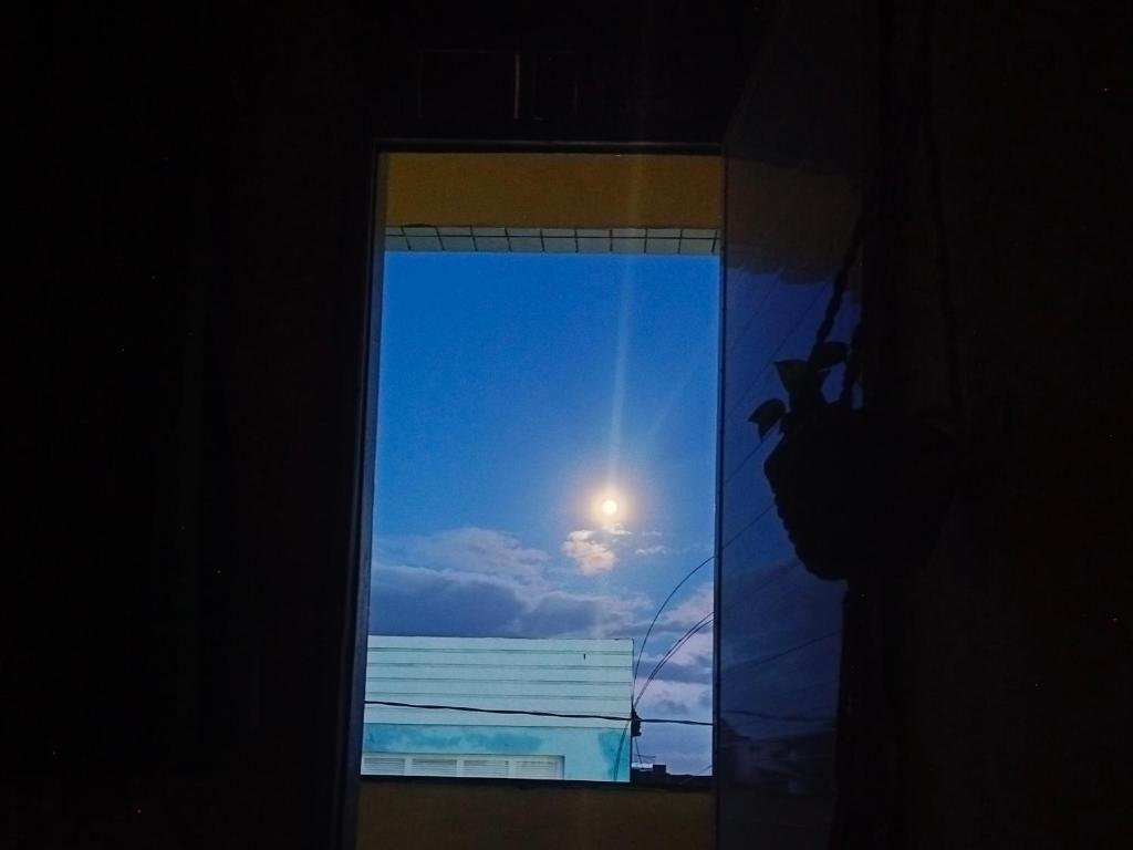 a window with a view of the ocean and the moon at Casa das Hortas in São Luís