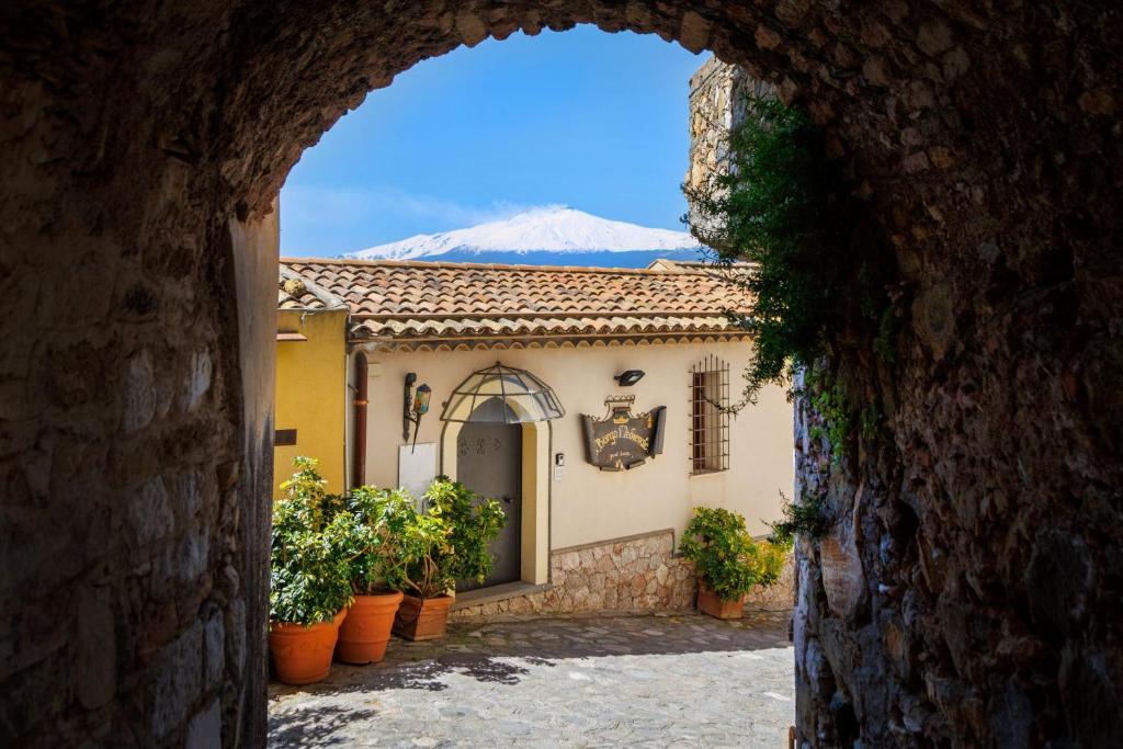 an archway into a building with a mountain in the background at Borgo Medievale in Castelmola