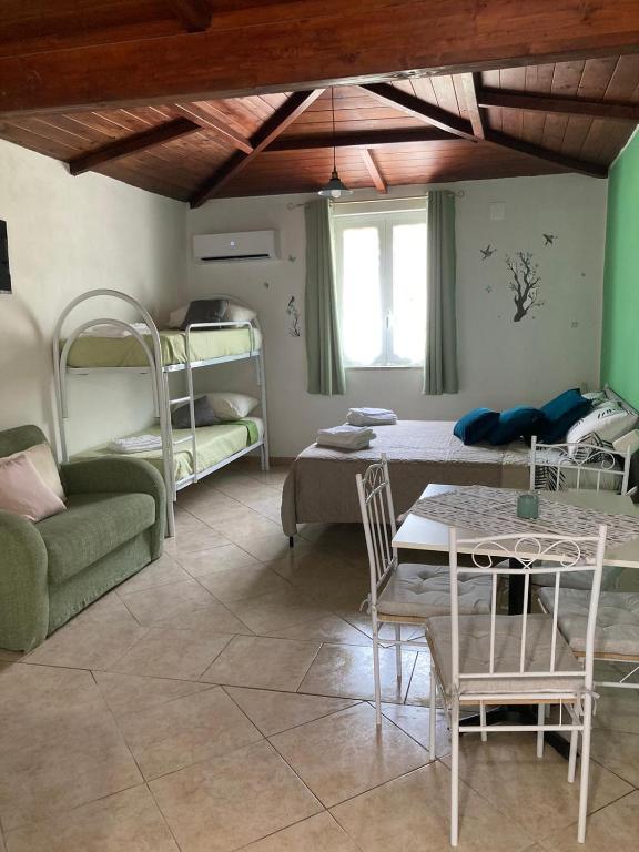 a living room with a table and chairs and bunk beds at L'Ulivo in Formia
