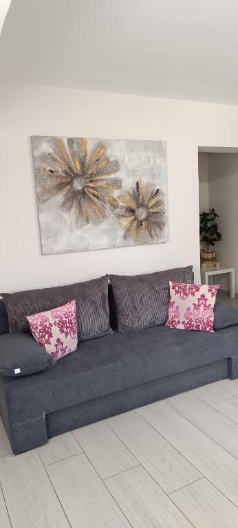 a blue couch with pink pillows in a living room at Sofia's Guest House in Levkákia