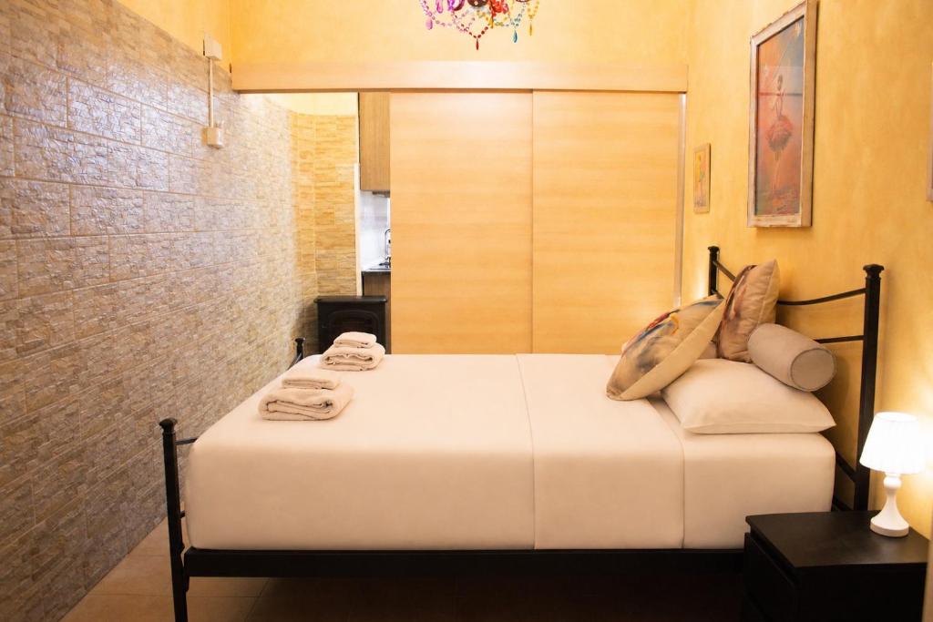 a bedroom with a bed with two towels on it at Domus Mazzini in Tivoli