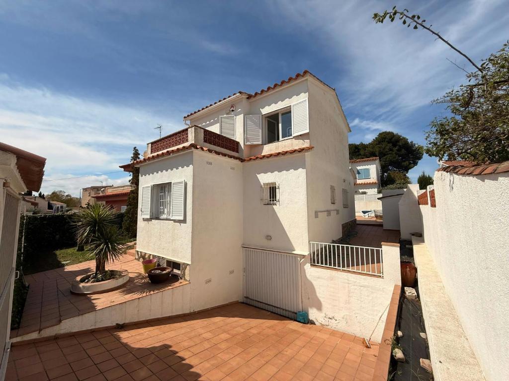 a white house with a fence and a courtyard at Villa Riells Mar in L'Escala