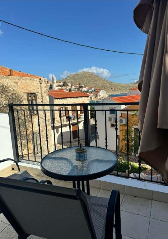 a table and chairs on a balcony with a view at House Katholiki in Halki