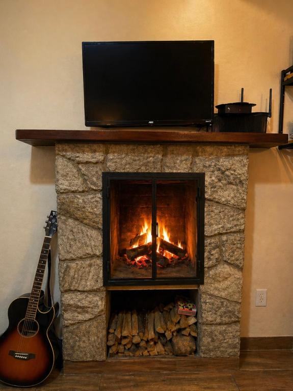 a fireplace with a television on top of it at Refúgios de Mauá - Chalé Serra in Visconde De Maua