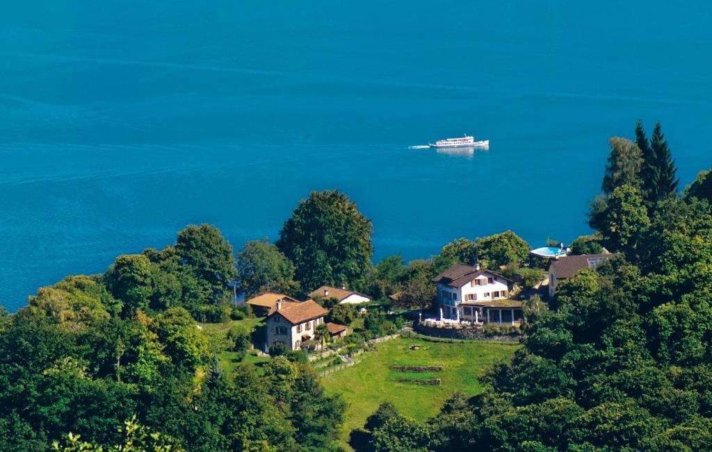 a plane flying over a house on a hill next to the ocean at Hotel Sass da Grüm in Vairano