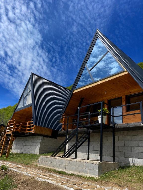 a house with a metal roof and glass at A&R cottages in Vusanje