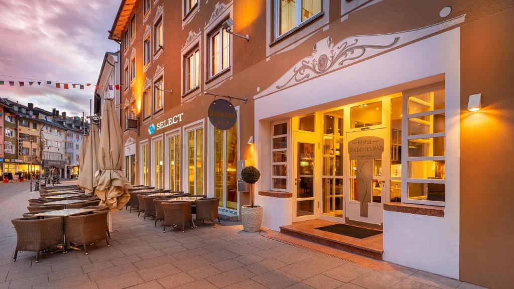 a street with tables and chairs in front of a building at Garner Hotel Friedrichshafen by IHG in Friedrichshafen