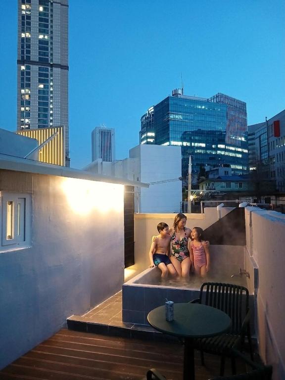 two children sitting on the ledge of a building at Hotel Soda STAY in Seoul