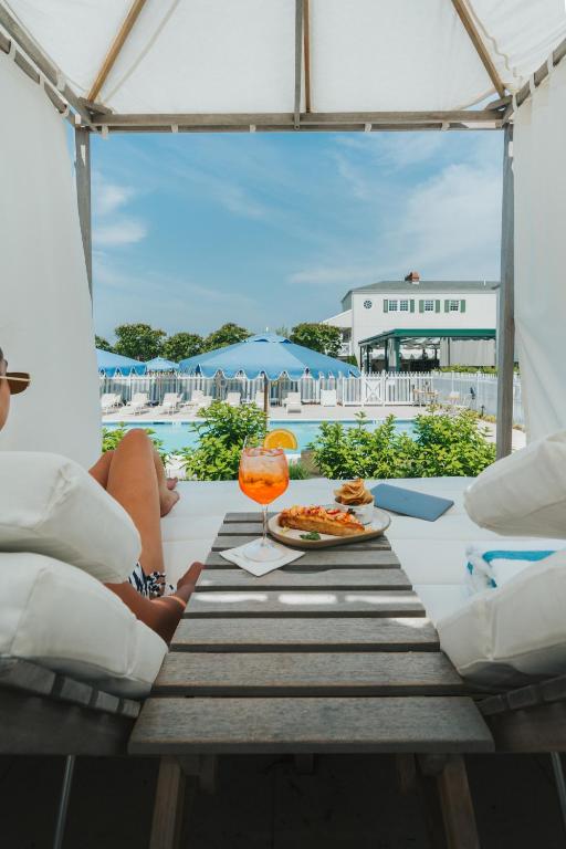 a table with a plate of food and a drink at Canoe Place Inn & Cottages in Hampton Bays