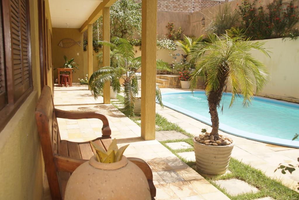 - une piscine avec un palmier dans la cour dans l'établissement Hospedaria Lua Raio de Sol, à Natal
